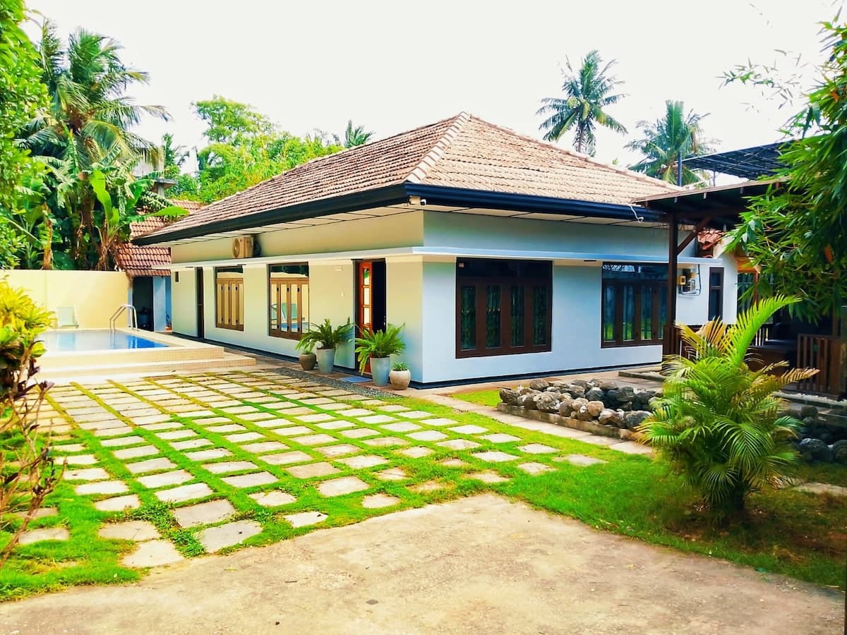 Abi Nila Villa — courtyard pool framed by colonnades and tropical foliage